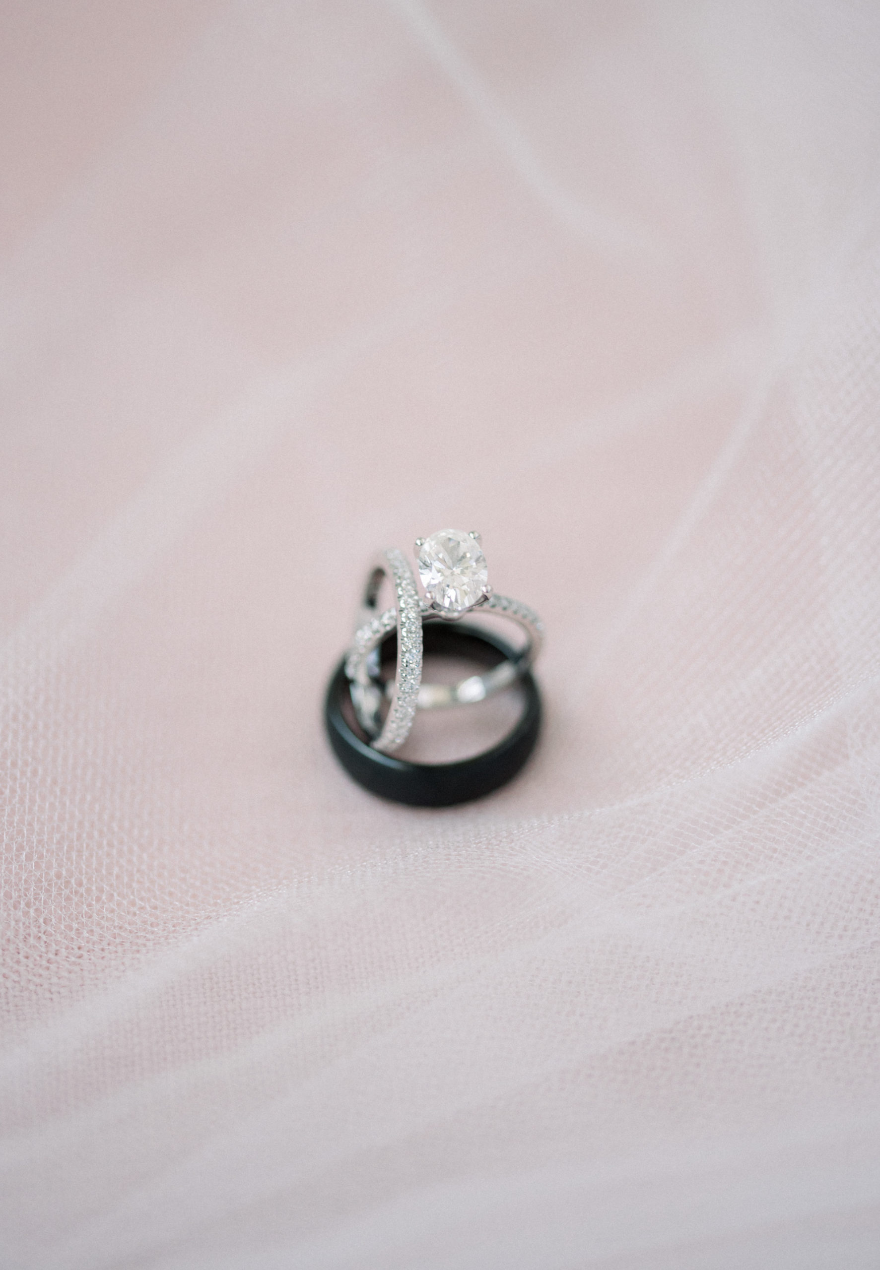 wedding ring details photos set up on a pink background with the veil