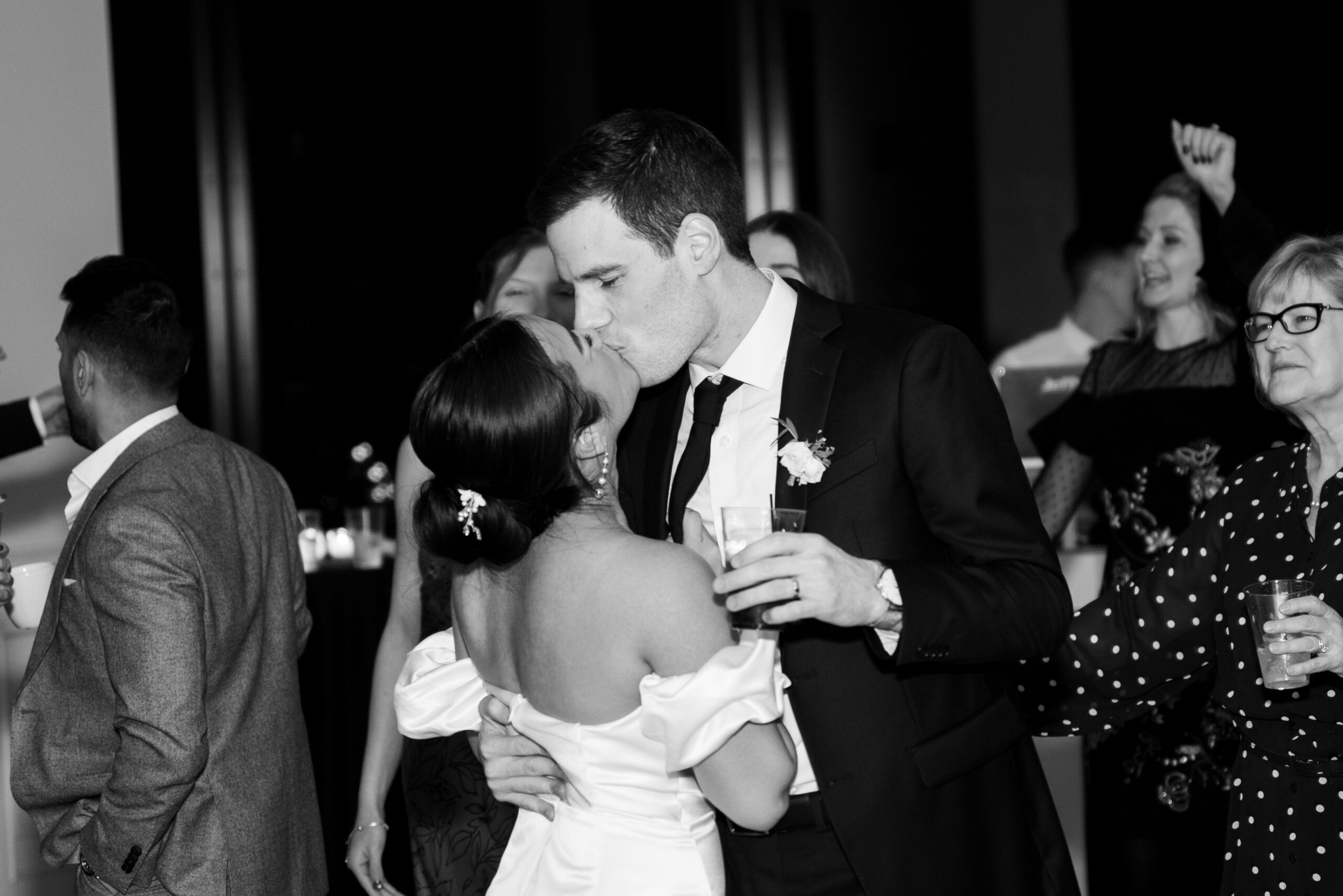 Couple during their reception at The View at Mt Adams. They are kissing and surrounded by some of their loved ones on the dance floor.